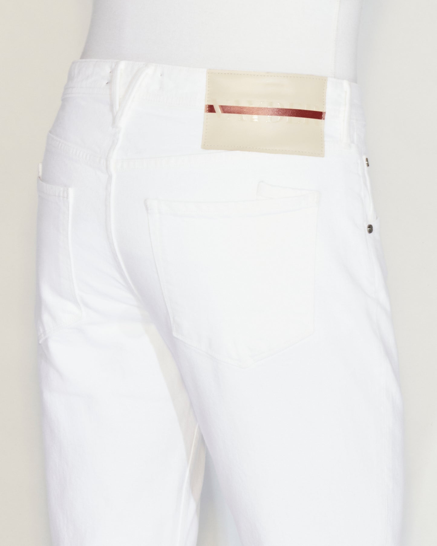 Man standing wearing white denim, a white tee and white shoes