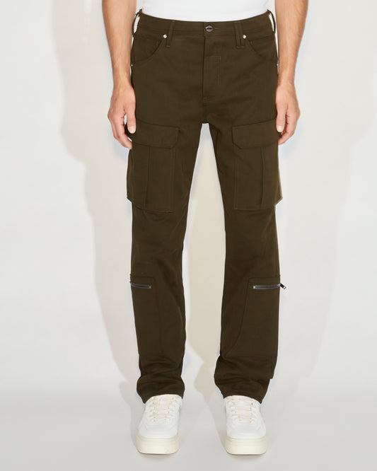 Man standing wearing green cargo pants with a white tee and white shoes