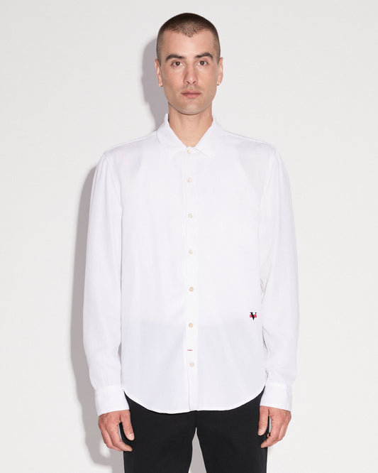 Man standing wearing a white long sleeve button up shirt with black pants