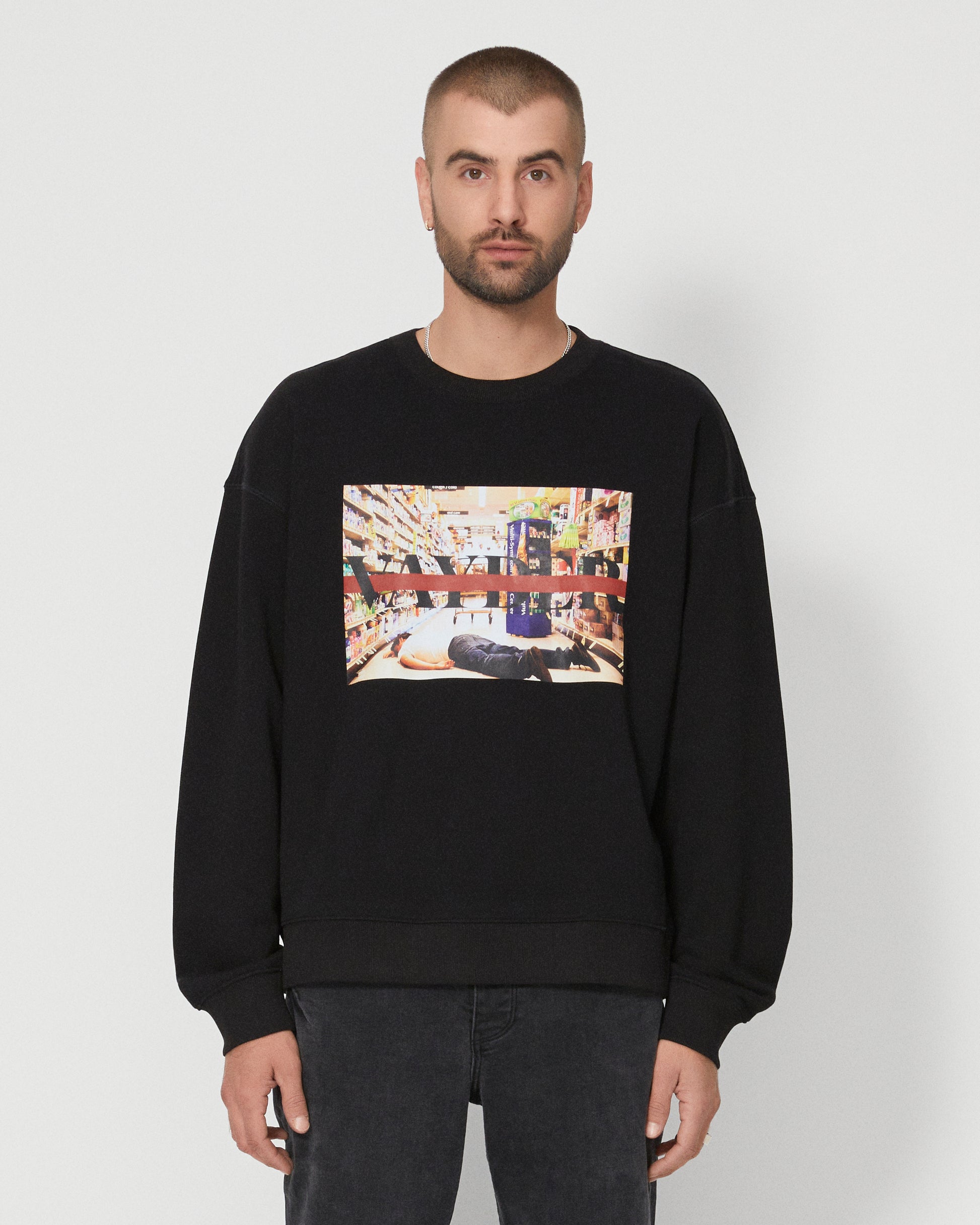 A man wearing a black sweatshirt with a picture on it.